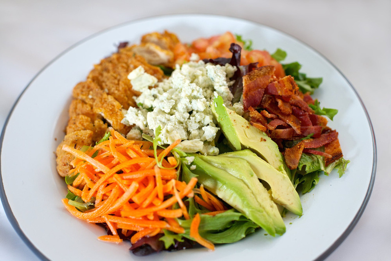 Salad with avocado, carrot, bacon and chicken.