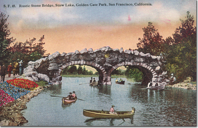historic stow lake bridge with row boats in the water.
